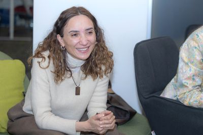 Միջոցառման մասնակից կինը նստած է 