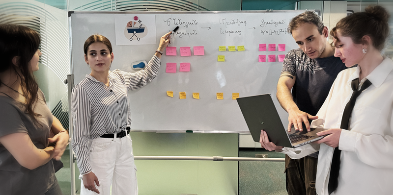 A group of young people discussing model for digitizing "Life Events" at a whiteboard
