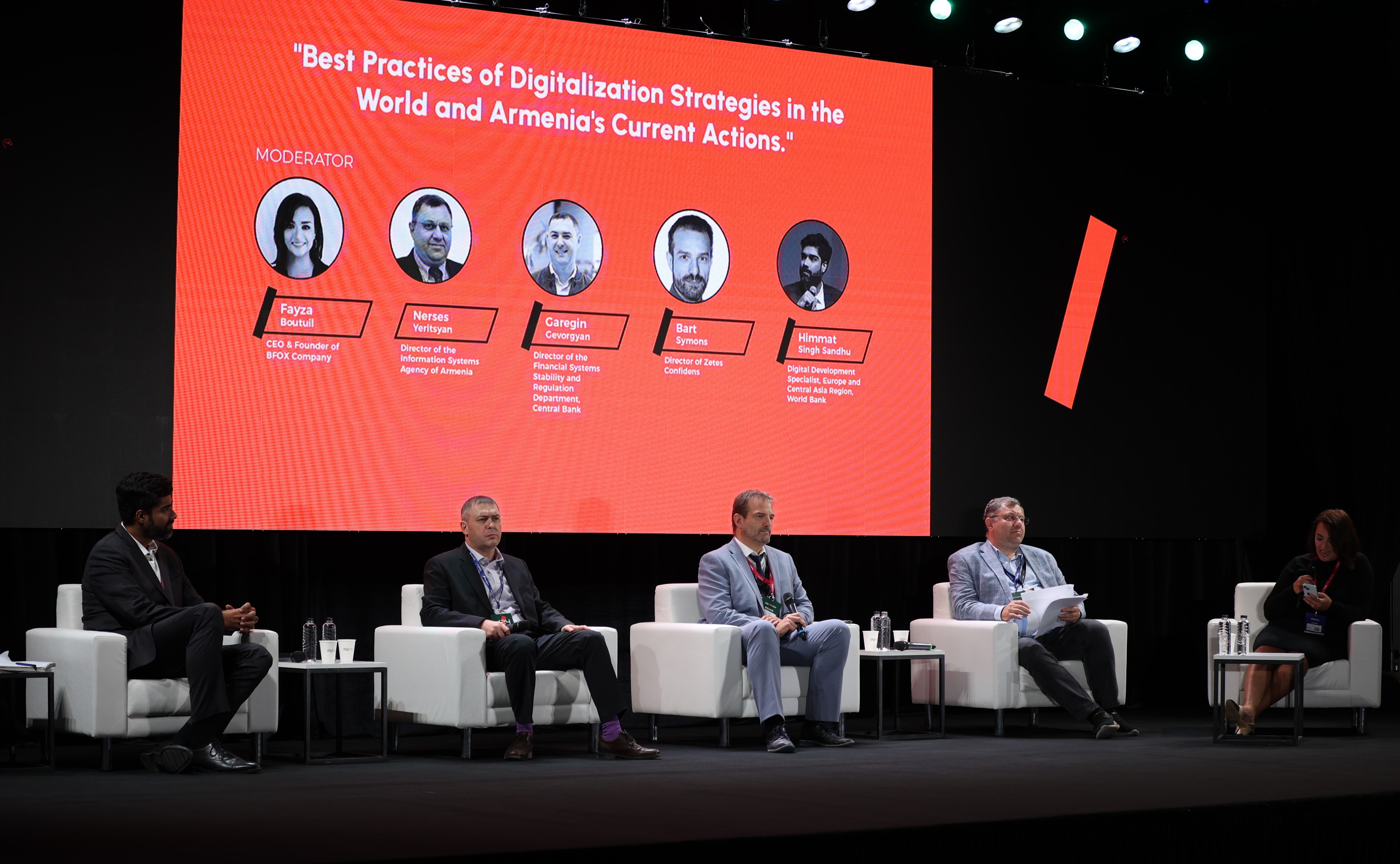 Five speakers with an orange screen behind them displaying their names. 